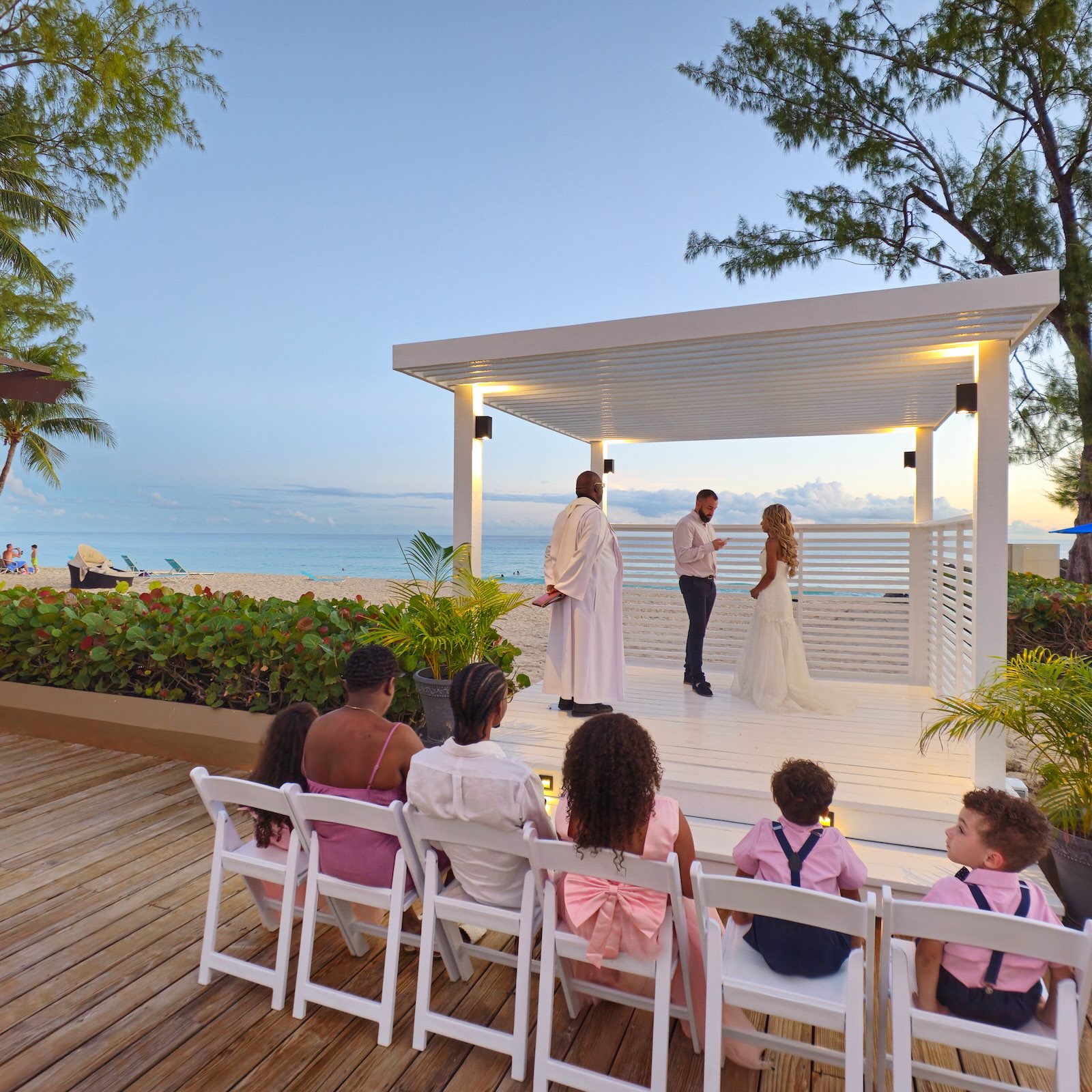 a group of people sitting in chairs on a deck next to a white structure