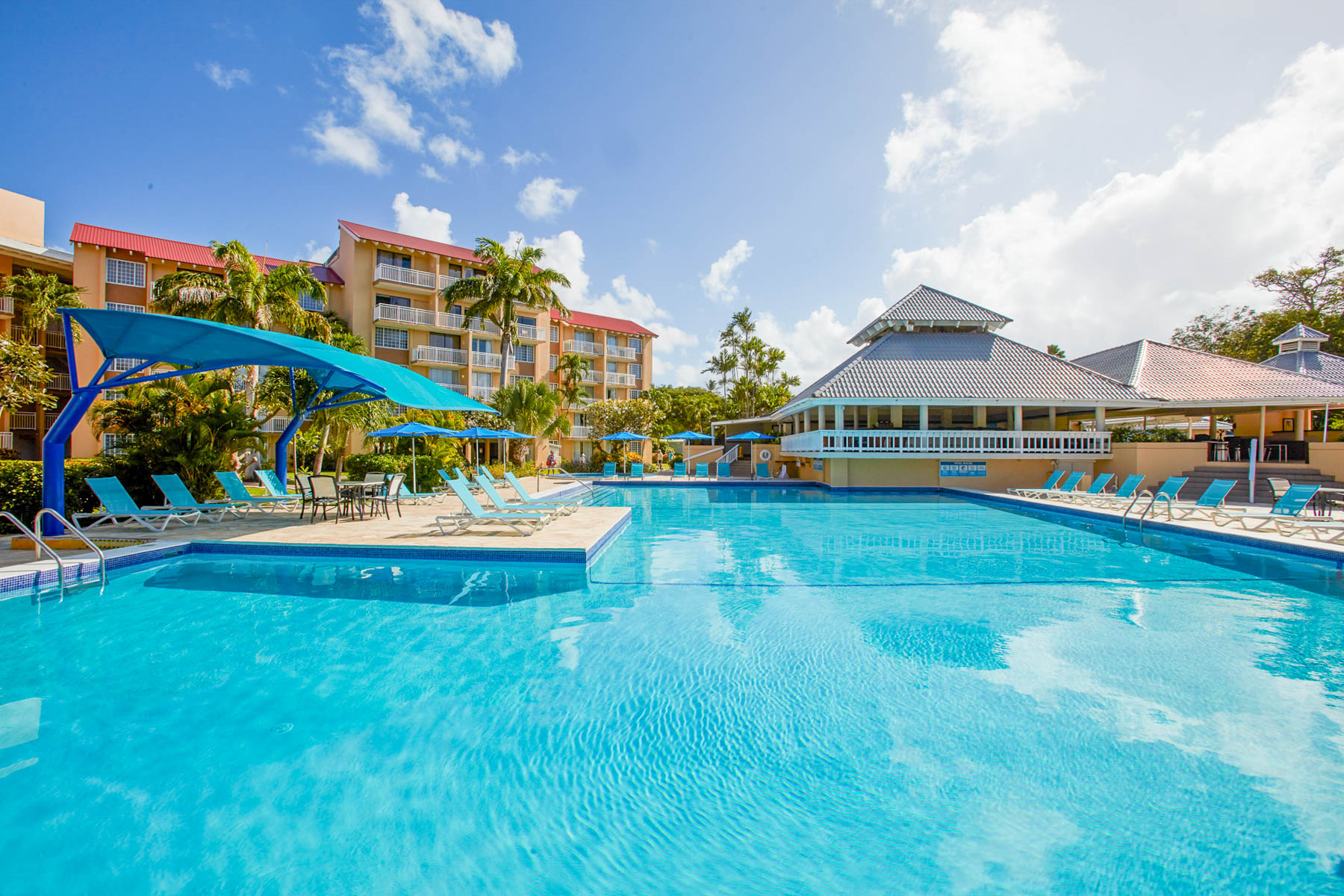 a swimming pool with a building and chairs